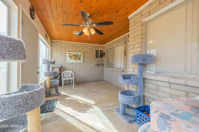 sunroom with ceiling fan and wood ceiling