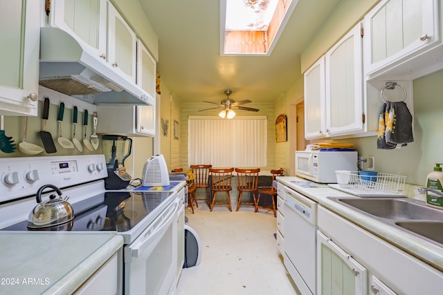 kitchen with a skylight, white appliances, ceiling fan, sink, and white cabinets