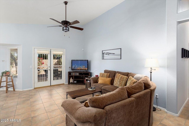 tiled living room featuring ceiling fan, a high ceiling, and french doors