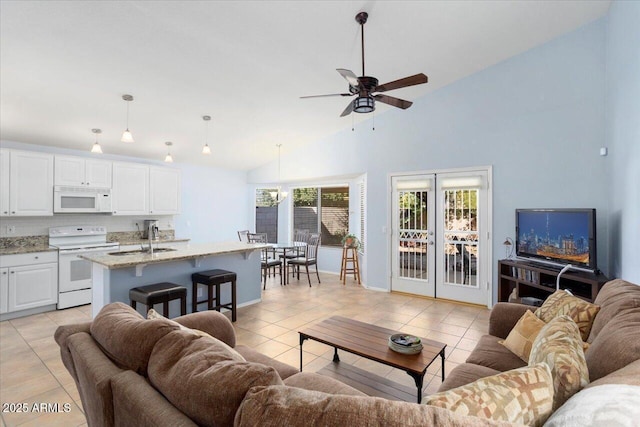 tiled living room featuring ceiling fan, sink, high vaulted ceiling, and french doors