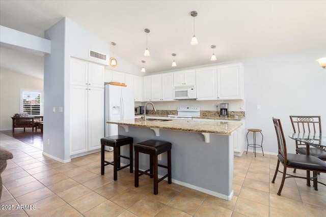 kitchen with pendant lighting, lofted ceiling, white cabinetry, and white appliances