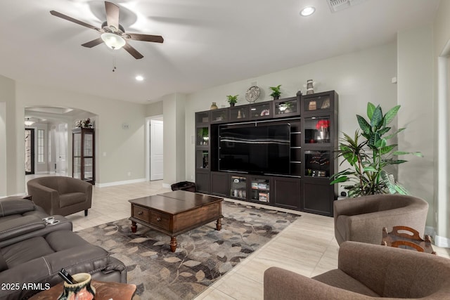living area featuring a ceiling fan, arched walkways, baseboards, and recessed lighting
