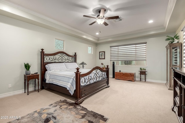bedroom featuring light carpet, baseboards, a tray ceiling, and ornamental molding