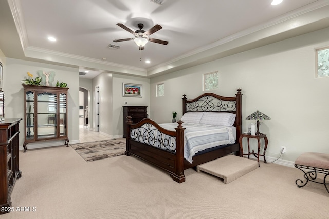 bedroom with arched walkways, light carpet, a raised ceiling, and visible vents
