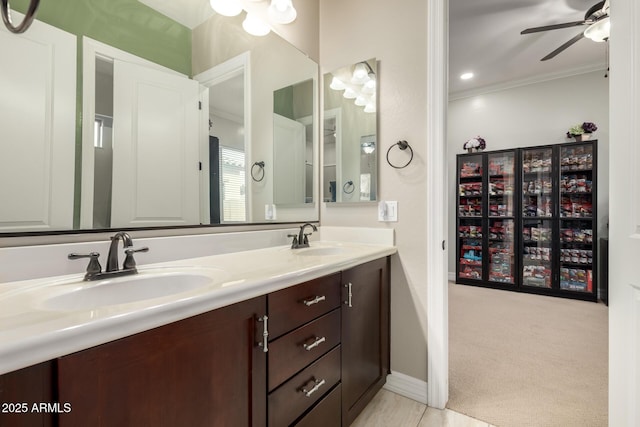bathroom with crown molding, a sink, ceiling fan, and double vanity