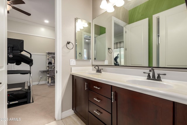 full bath featuring crown molding, a sink, baseboards, and double vanity