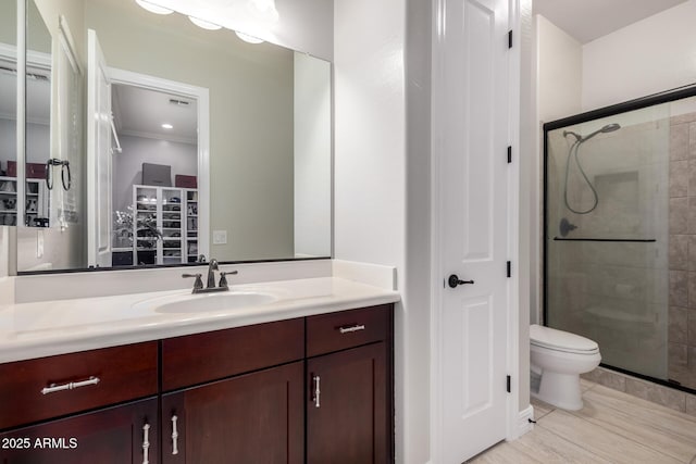 bathroom with toilet, a shower stall, and vanity
