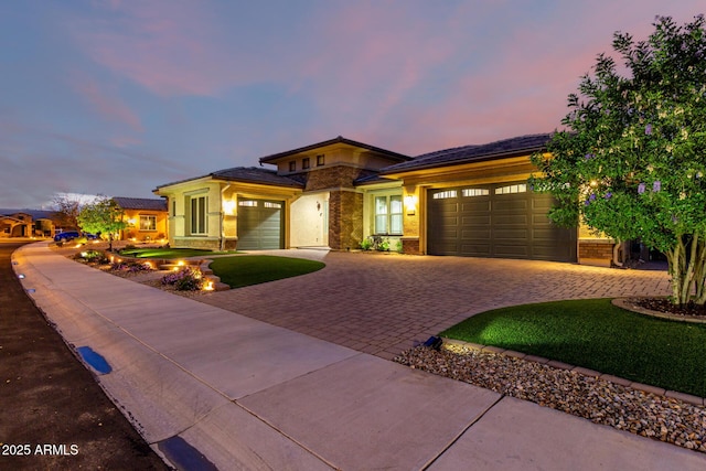 prairie-style house with decorative driveway and an attached garage