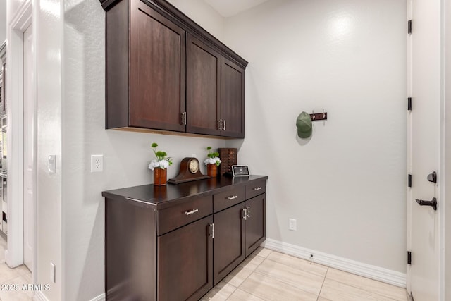interior space with light tile patterned flooring and baseboards