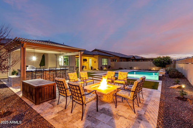 exterior space with a fenced in pool, outdoor dry bar, an outdoor kitchen, an outdoor fire pit, and a fenced backyard