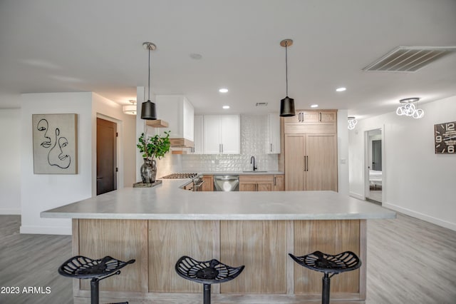 kitchen with decorative backsplash, appliances with stainless steel finishes, decorative light fixtures, and white cabinetry