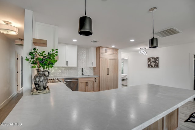 kitchen featuring stainless steel dishwasher, white cabinets, light brown cabinetry, and tasteful backsplash