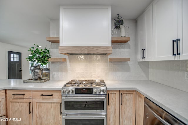 kitchen with white cabinets, backsplash, and stainless steel appliances