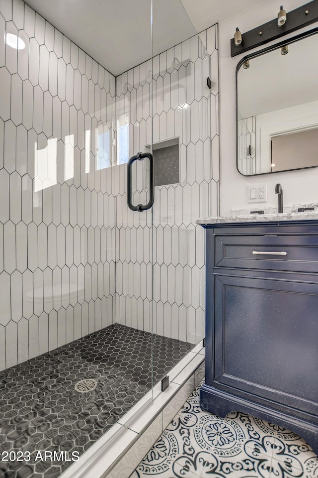 bathroom with tile patterned floors, vanity, and a shower with door