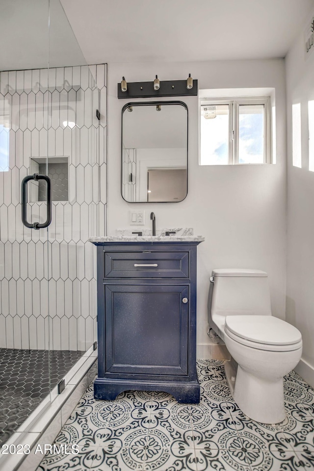 bathroom featuring tile patterned flooring, vanity, toilet, and an enclosed shower