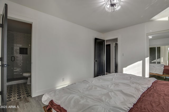 bedroom featuring ensuite bathroom and hardwood / wood-style floors