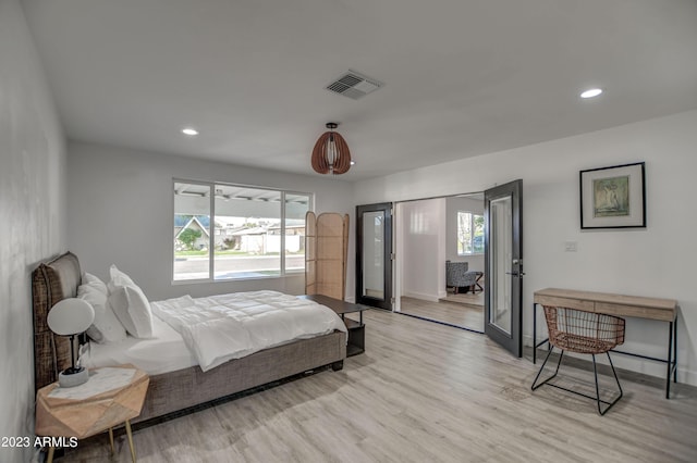 bedroom with light wood-type flooring and french doors