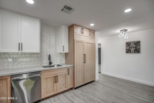 kitchen with paneled refrigerator, sink, light brown cabinets, dishwasher, and light hardwood / wood-style floors