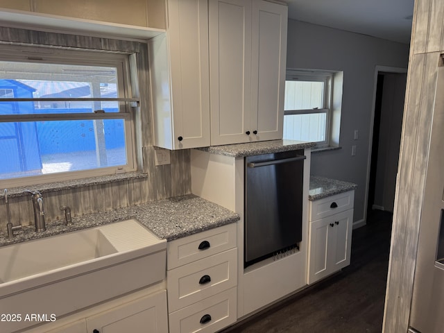 kitchen with white cabinetry, black dishwasher, sink, light stone counters, and dark wood-type flooring