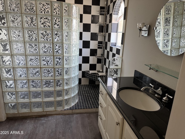 bathroom featuring vanity, wood-type flooring, and tiled shower