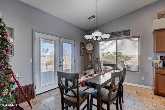 dining space with french doors, a chandelier, and lofted ceiling