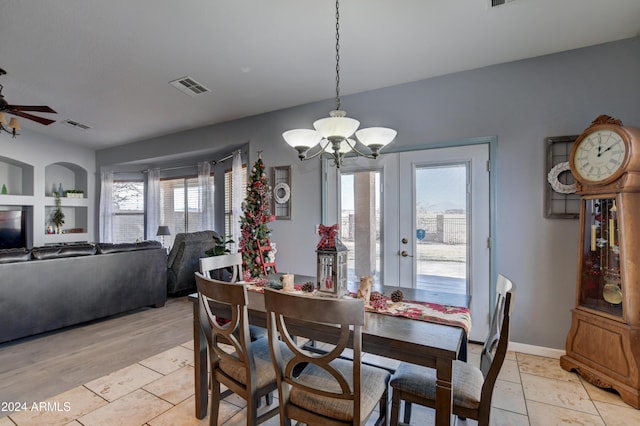 dining room with ceiling fan with notable chandelier and light wood-type flooring