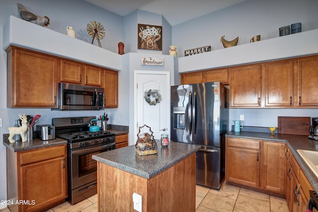 kitchen with a center island, light tile patterned floors, appliances with stainless steel finishes, and a towering ceiling