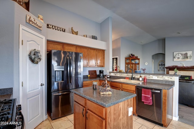 kitchen featuring sink, a center island, kitchen peninsula, light tile patterned flooring, and appliances with stainless steel finishes