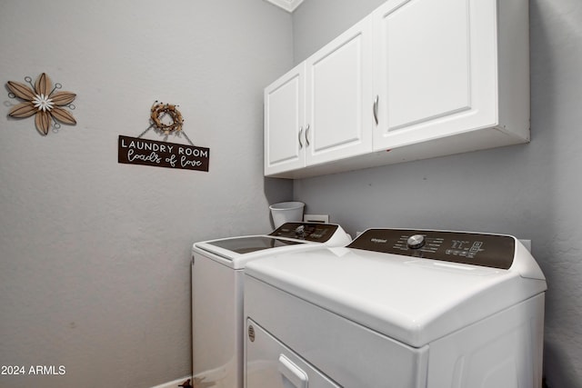 washroom featuring cabinets and separate washer and dryer