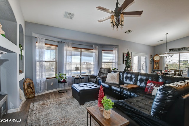 living room with a wealth of natural light, ceiling fan, vaulted ceiling, and hardwood / wood-style flooring