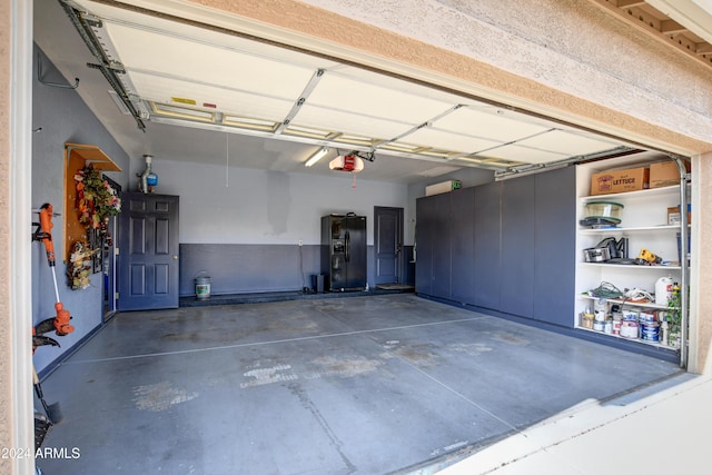 garage with black fridge with ice dispenser and a garage door opener