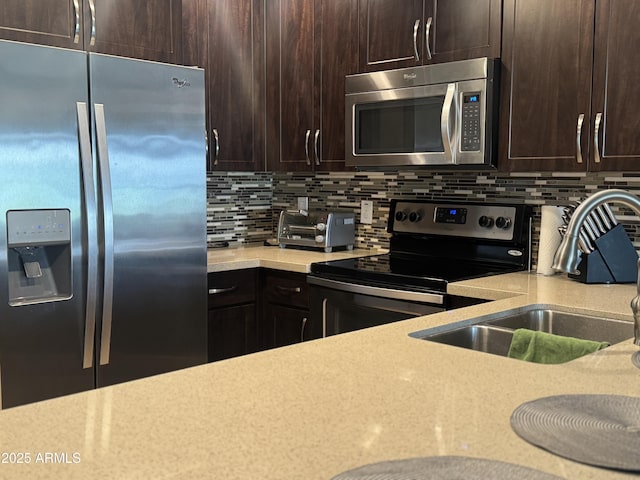 kitchen featuring dark brown cabinets, a sink, appliances with stainless steel finishes, and tasteful backsplash