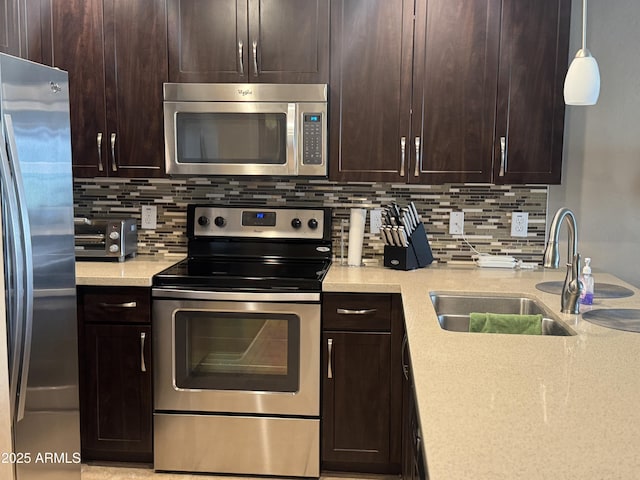 kitchen featuring backsplash, dark brown cabinetry, stainless steel appliances, and a sink