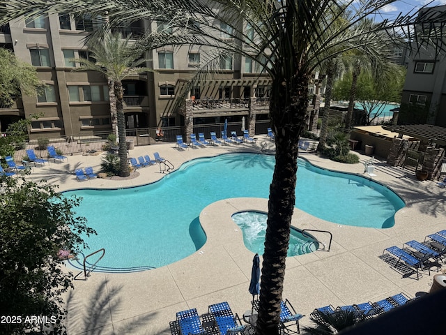 community pool featuring fence and a patio area