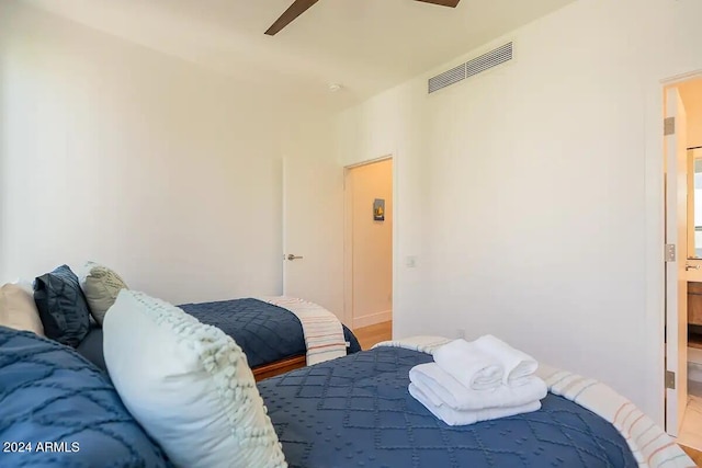 bedroom featuring connected bathroom, ceiling fan, and hardwood / wood-style flooring