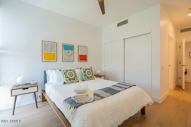 bedroom featuring ceiling fan, light hardwood / wood-style floors, and a closet