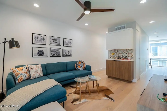 living room with ceiling fan and light wood-type flooring