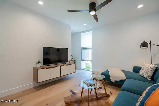 living room featuring ceiling fan and light hardwood / wood-style floors