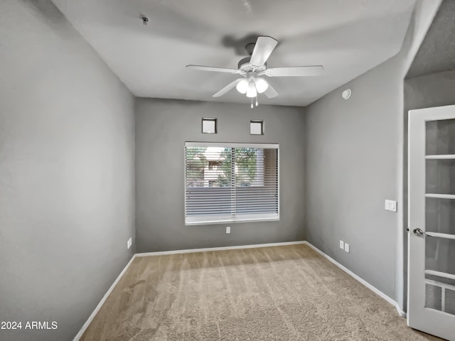 carpeted spare room with ceiling fan