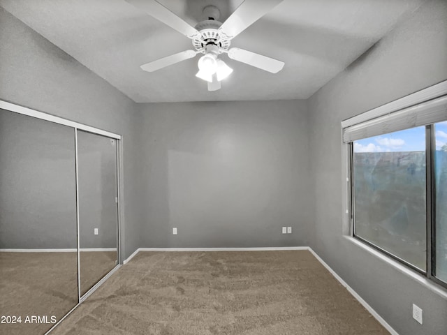 unfurnished bedroom featuring carpet, a closet, and ceiling fan