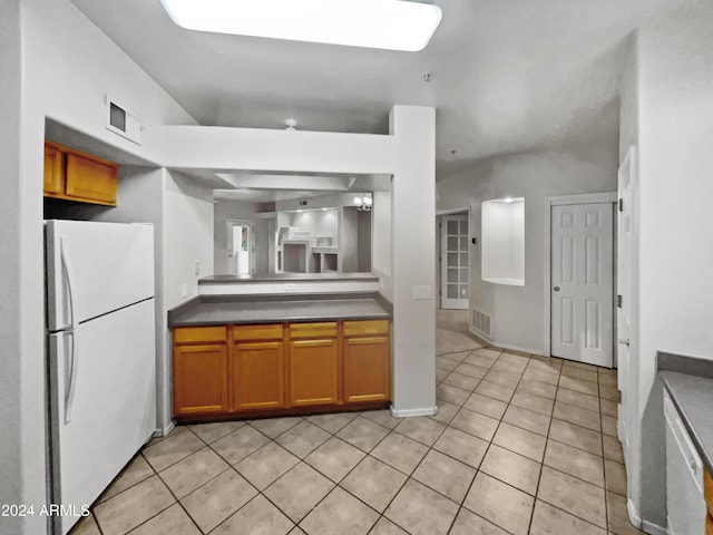 kitchen featuring light tile patterned floors, white fridge, and a notable chandelier