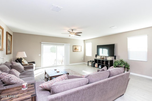 living room with ceiling fan and light hardwood / wood-style flooring