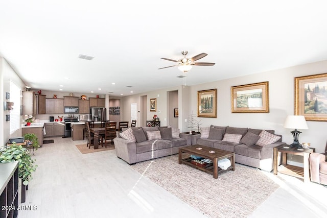 living room with ceiling fan and light hardwood / wood-style floors