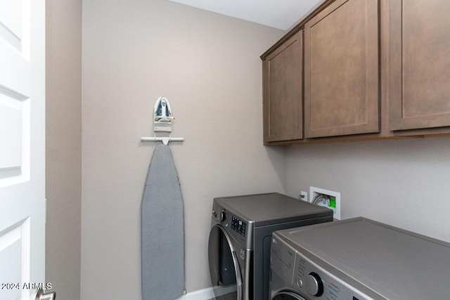 laundry room with cabinets and washer and dryer