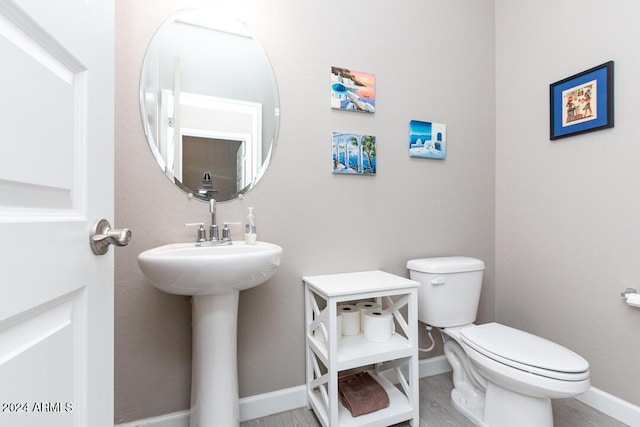 bathroom featuring hardwood / wood-style flooring and toilet