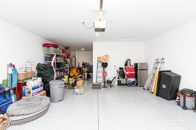 garage featuring stainless steel refrigerator and a garage door opener