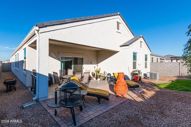 rear view of house featuring cooling unit and a patio