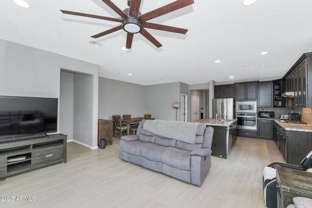 living room with ceiling fan and sink