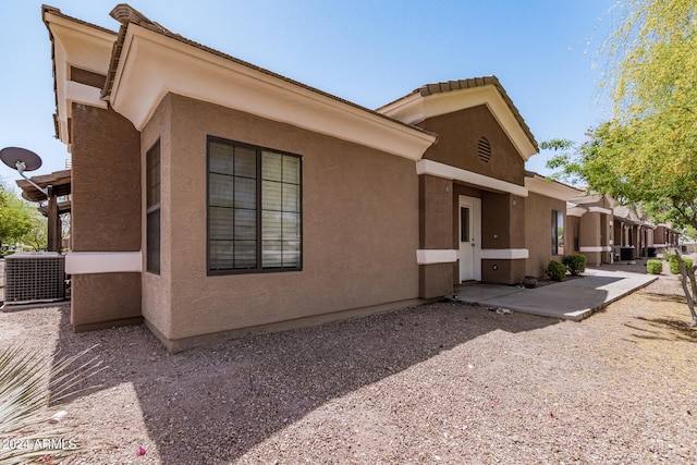 view of side of property featuring a patio area and central AC