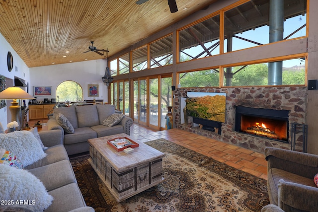 living area with a fireplace, ceiling fan, high vaulted ceiling, and wooden ceiling